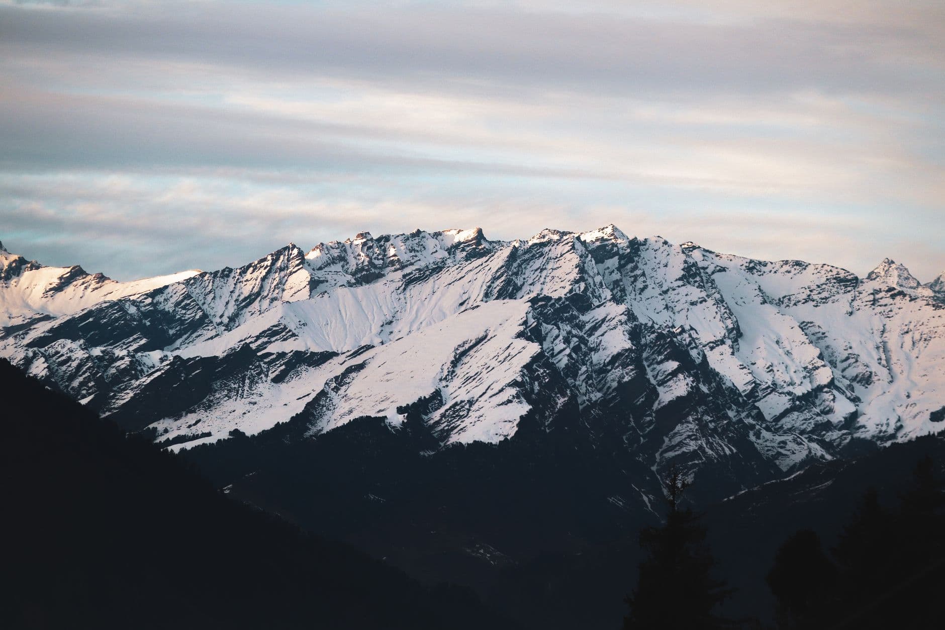 Snow-dusted Himalayan ridgelines under a soft haze